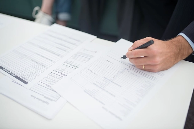 Persona revisando y firmando contrato de compra de casa