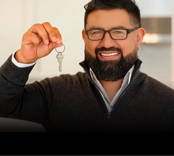 Eduardo Camargo sonriendo y mostrando las llaves de una nueva casa