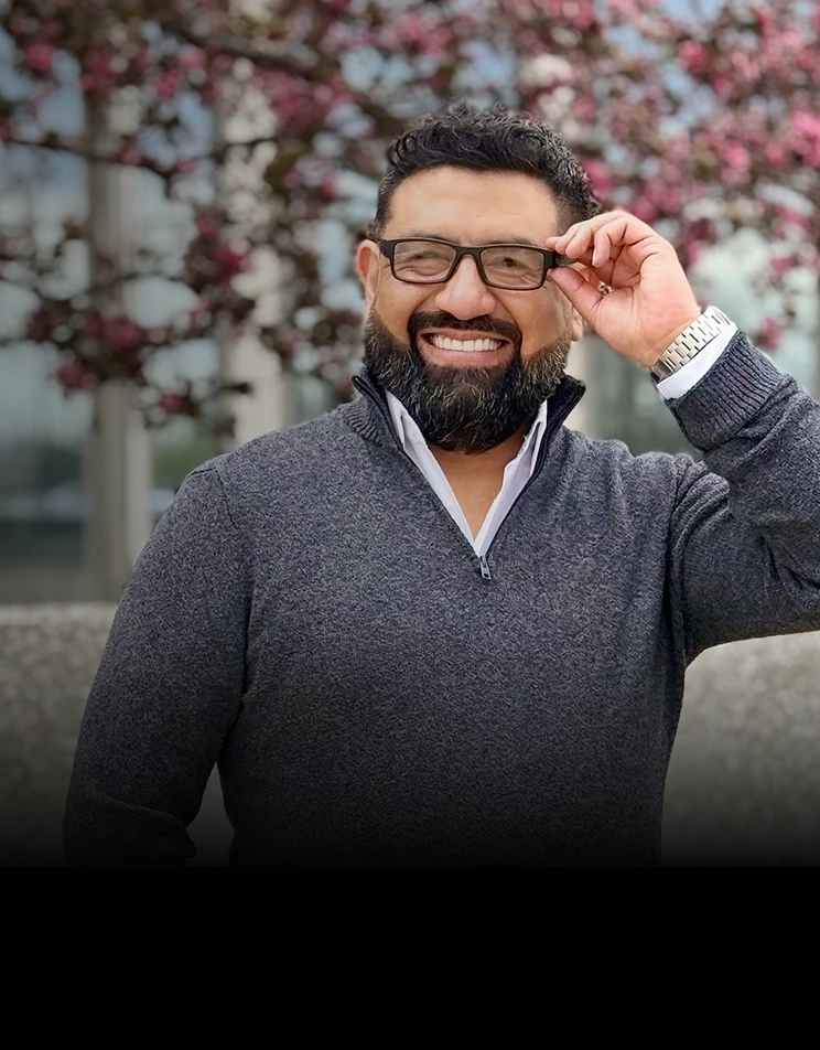 Eduardo Camargo sonriendo frente a una casa vendida con las llaves en la mano
